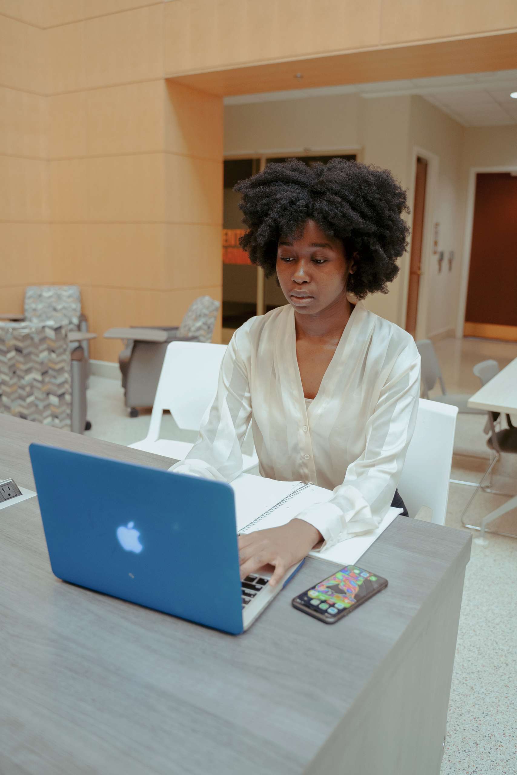 Young black woman sits at laptop.